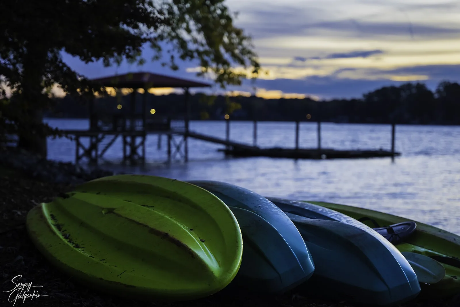 Kayaks on the shore of Lake Norman at dusk.