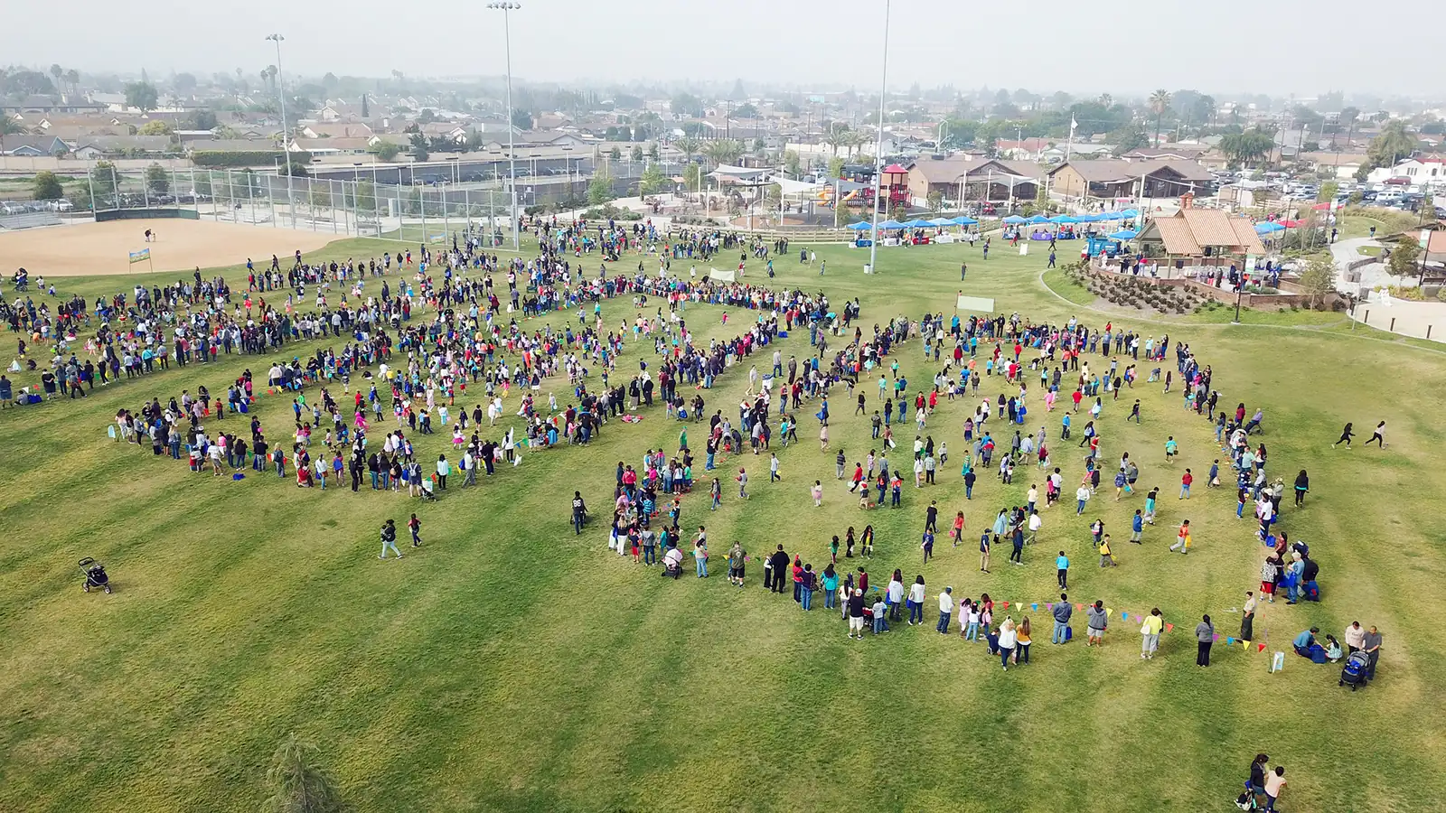Children spread out across a park lawn at a community Easter egg hunt in Stanton, California.