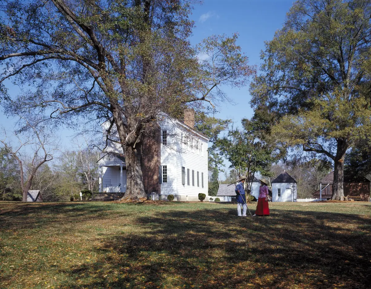 The historic Latta house and its outbuildings at Latta Nature Preserve in Huntersville, with costumed interpreters on the lawn.