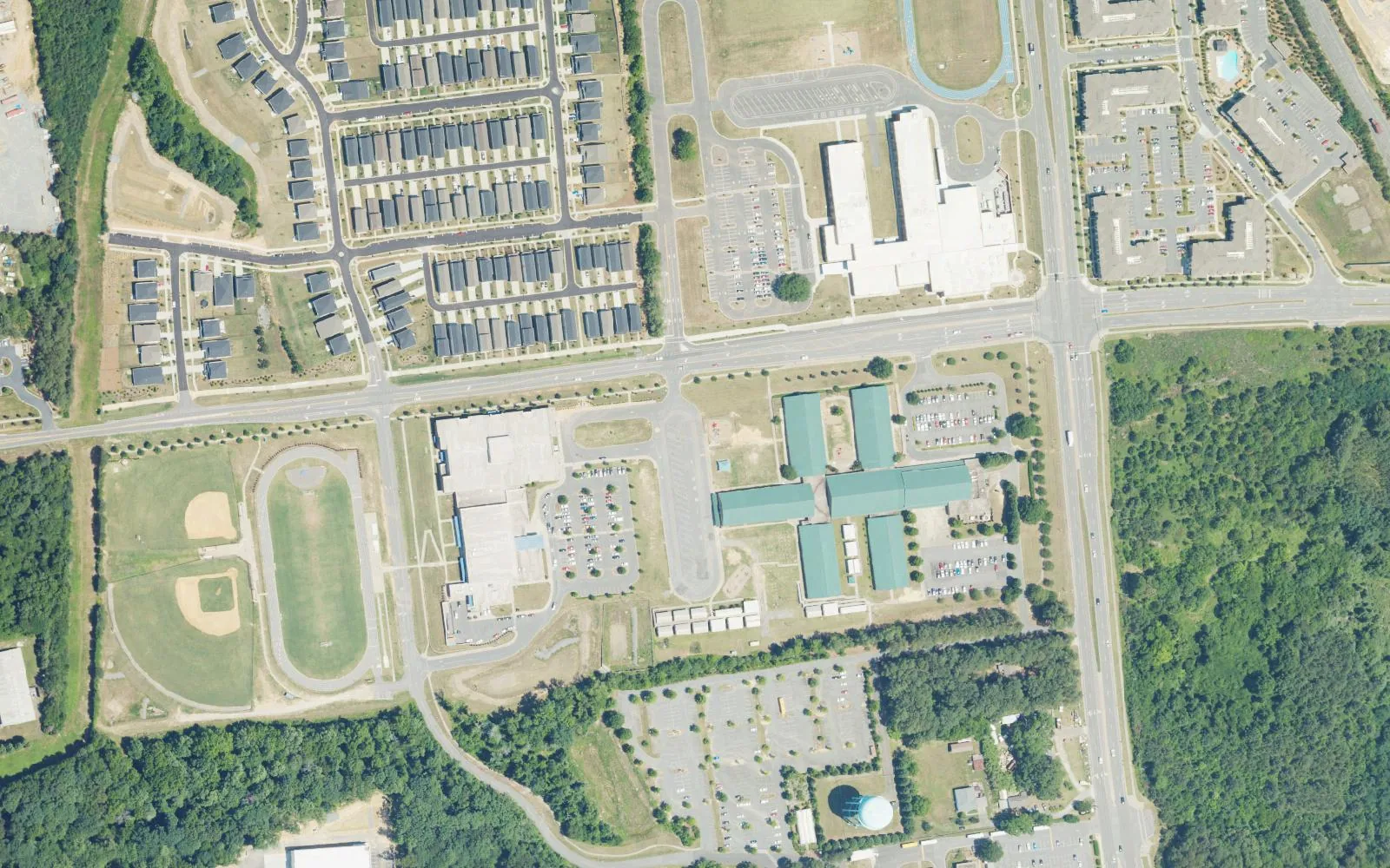 School campuses along Hambright Road in south Huntersville, with rows of new homes to the north, seen from the air