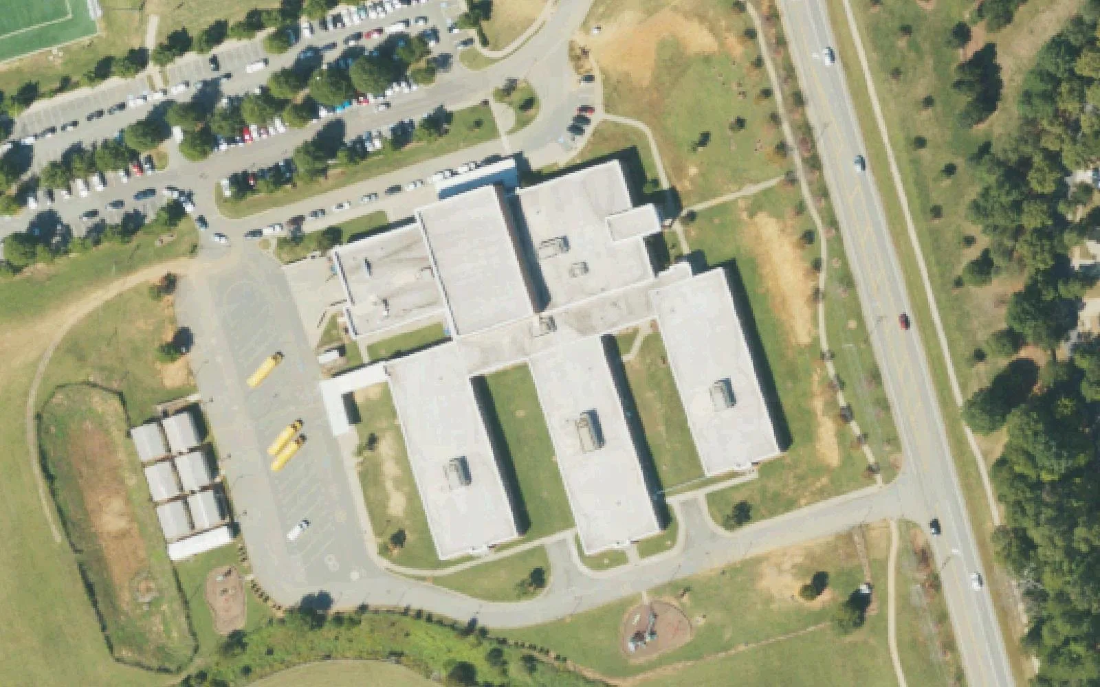 Barnette Elementary School's classroom wings, mobile classrooms and parking lot beside Beatties Ford Road in west Huntersville, seen from the air