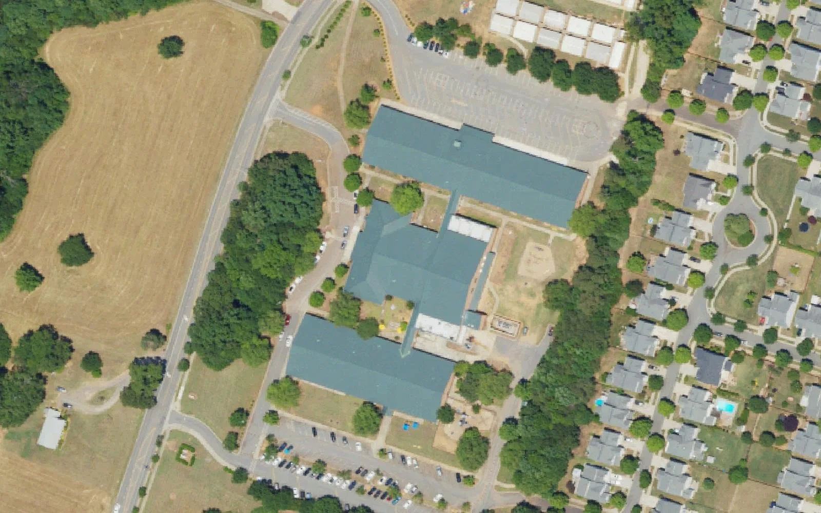 Torrence Creek Elementary School's classroom buildings and parking lots beside Ranson Road in Huntersville, with homes to the east, seen from the air