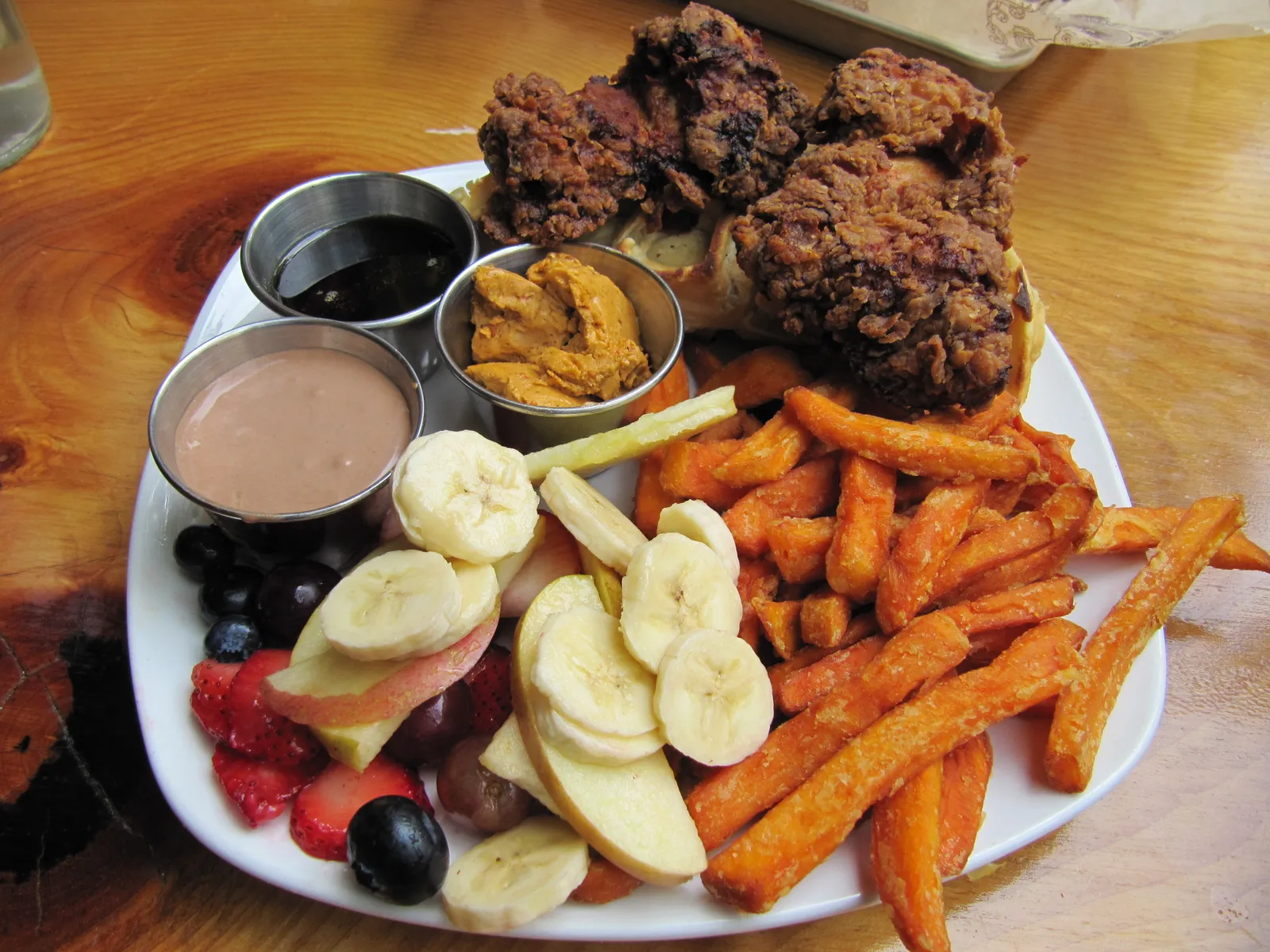 A brunch plate of fried chicken and waffles, sweet potato fries and fruit; the photo does not show a Huntersville restaurant.
